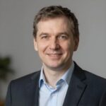 Портрет уверенного российского бизнесмена с дружелюбным взглядом на нейтральном фоне для раздела отзывов